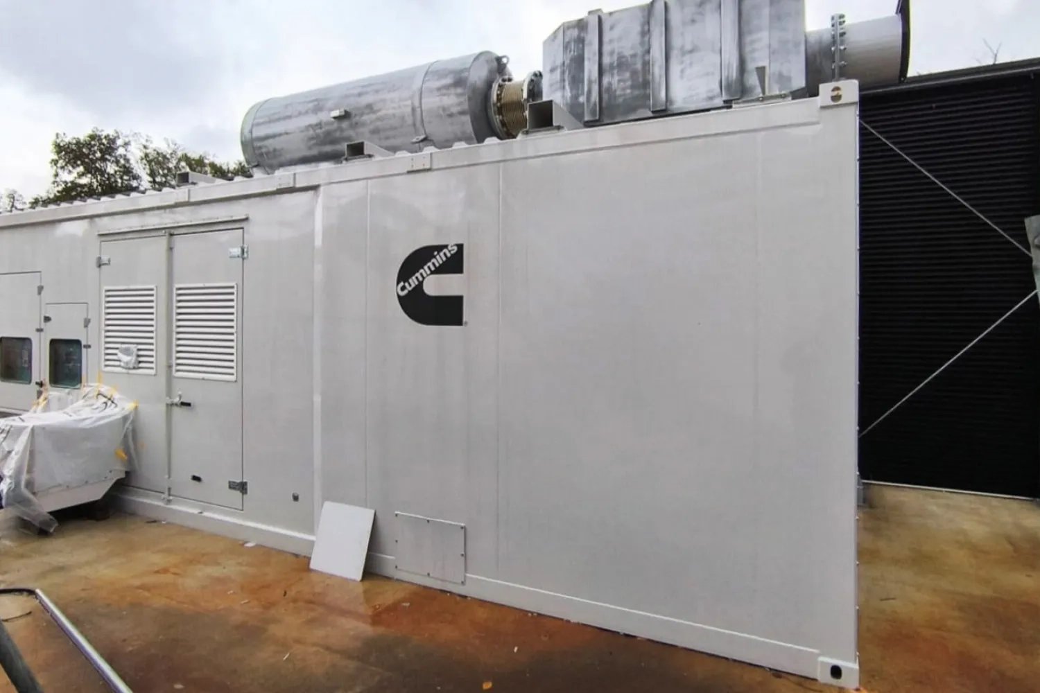 Containerized Cummins generator with roof-mounted exhaust silencer