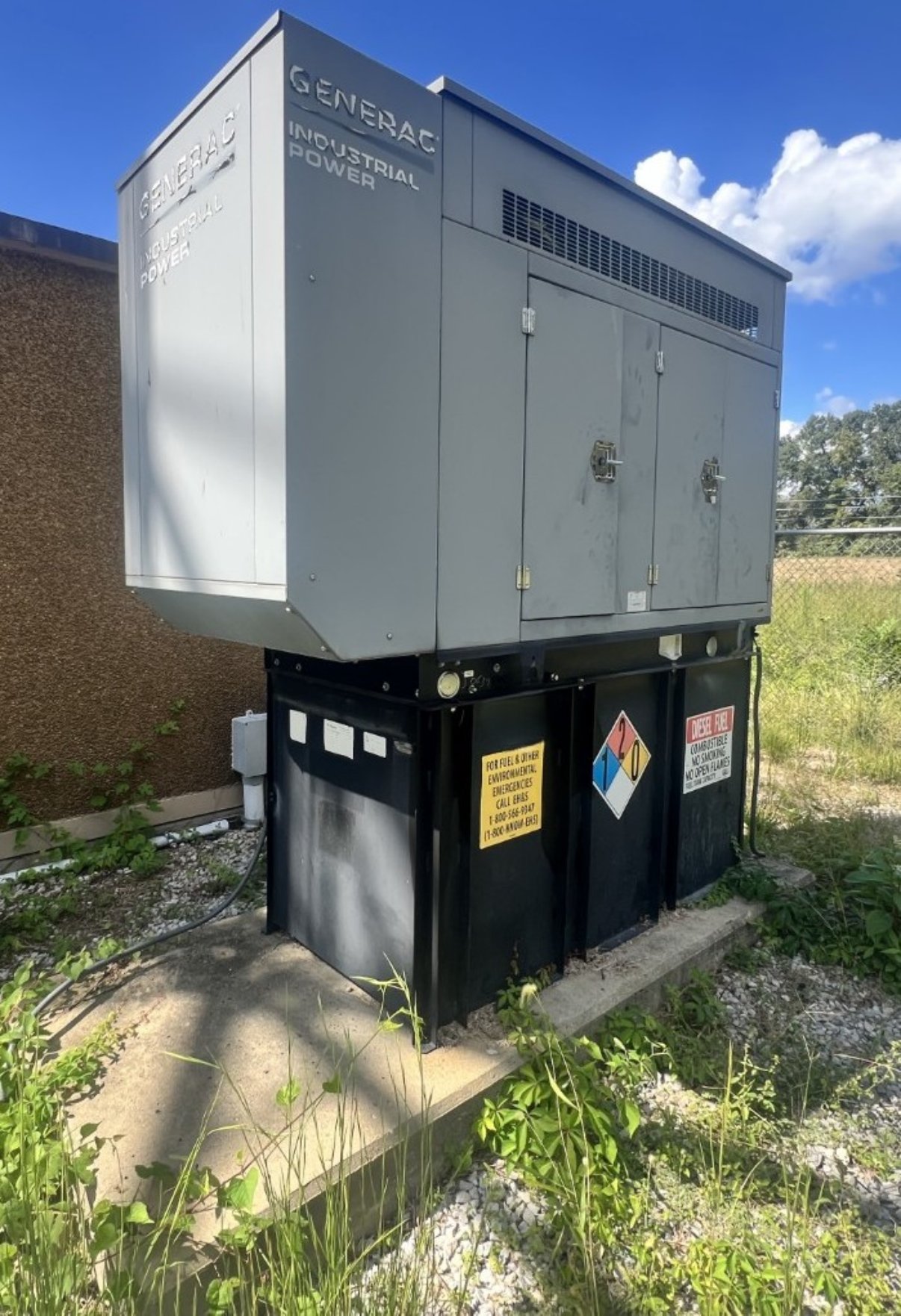 Generac industrial diesel generator on sub-base fuel tank at commercial site